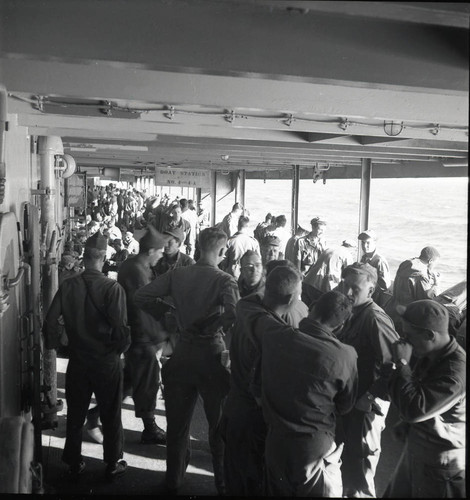 Troops crowded onto a weather deck of the USS Meigs