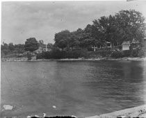 People on lawns of houses by the water, c. 1912