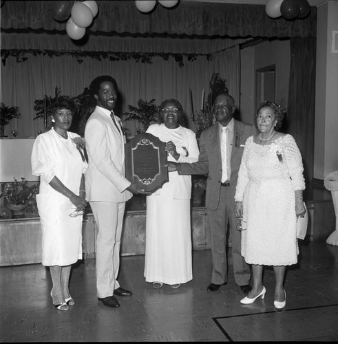 An African American couple receiving a commemorative plaque, Los Angeles