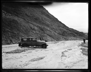 Trapped automobile in the torrential flow of water from Gratto Canyon near Stove Pipe Wells in Death Valley, January 1928