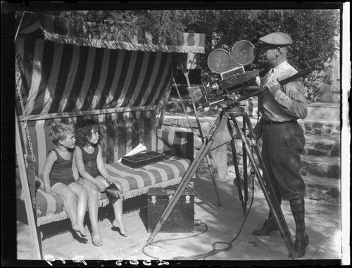 Two Estes children on glider swing posing for cameraman, [Van Nuys?], between 1928 and 1936