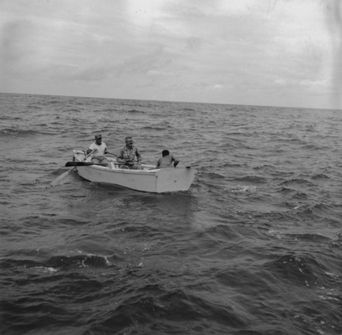 John D. Isaacs (middle), Willard Bascom (back to camera) and unidentified man in skiff, Bikini Atoll area