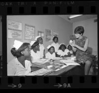 Harriet Goslins conducting a dental assistant training class to seven African American girls in Watts, Calif., 1967
