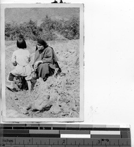 A Maryknoll Sister with a child in the fields at Dongshi, China, 1948