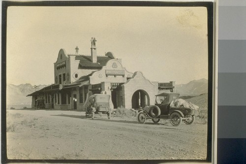 On the opposite page is a picture of the railway depot, Rhyolite, Nev. This building was constructed of stone but time is slowly doing its work as may be noticed on the sign facing the machines; The Railway Depot, Rhyolite Nevada