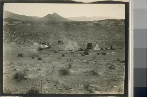 We try to locate Stovepipe Wells but after wandering around some terrible roads the likes of which may be seen in the background we make camp here at 5 p.m. Jan. 11, 32 miles, falling down fast on that milage. Billyan's one cylinder stove is hitting on all the cylinder as may be seen on the left of the picture