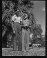 Defendant Roy Randolph and woman outdoors near palm tree, 1937