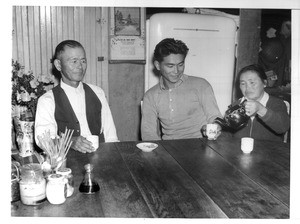 "Afternoon tea at the home of the Dote family in Los Angeles. Left to right: Nasaichi Dote (Issei), father; Tosh Dote (Nisei), son, and Sada Dote (Issei), mother."--caption on photograph