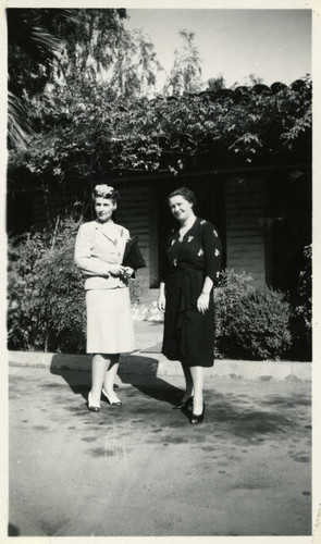 1940, Two Library Staff Standing in Front of a Brick Building