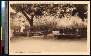 Children sit on benches under a tree, Kinshasa, Congo, ca.1900-1930