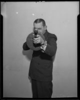 Vince Higgins, an investigator for the District Attorney, holds a machine gun, Los Angeles, 1935