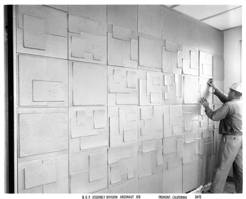 Worker Placing Decorative Tiles on a Wall of a Fremont GMC Plant Building