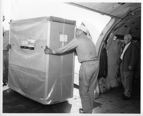 Two Workers Loading IBM Data Processing Equipment Onto Transport Plane