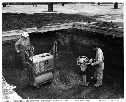 Two Workers Operating Compactors at the GMC Plant Building Site