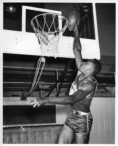 San Jose State College Basketball Player Slam-Dunking a Football