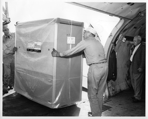 Two Workers Loading IBM Data Processing Equipment Onto Transport Plane