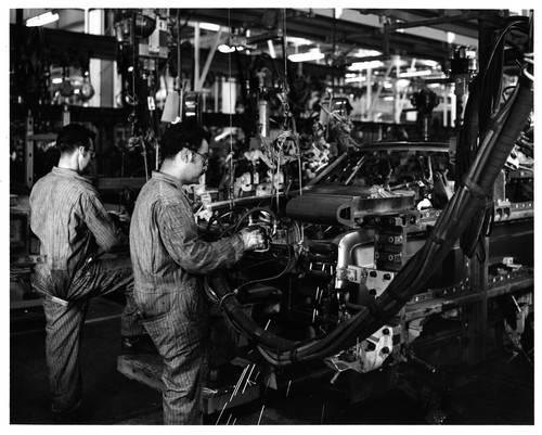 Workers Engaged in Manual Assembly of Automobiles at the Fremont GMC Plant