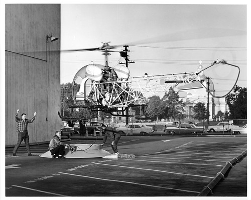 View of Telephone Co. Helicopter Taking Off to Airlift Rooftop Satellite Dish