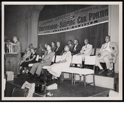 Brotherhood of Sleeping Car Porters leadership seated behind lectern at session of the 28th anniversary of the Brotherhood of Sleeping Car Porters, Los Angeles Division