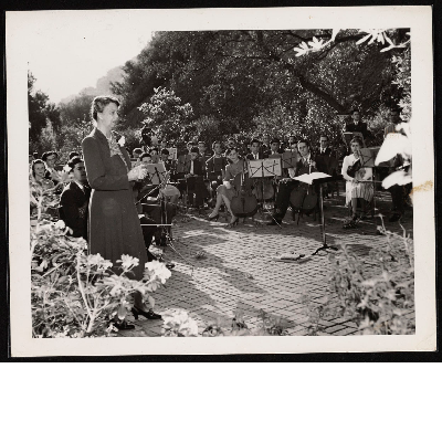 Eleanor Roosevelt speaking in courtyard with musicians in the background