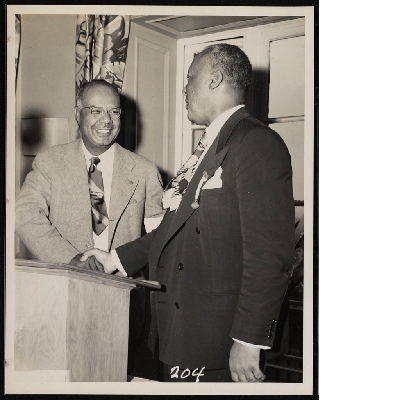 A. Philip Randolph shaking hands with unidentified man