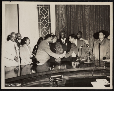 Ralph Bunche and Vincent Impellitteri shaking hands, also pictured (left-right): Ashley Totten, Thomas T. Patterson, Mrs. E.J. Bradley, Ralph Bunche, Mrs. M.P. Webster, A. Philip Randolph, Vincent Impellitteri, B.F. McLaurin, Mrs. McLaurin