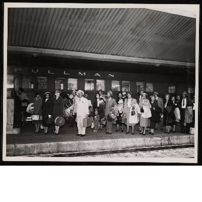 Attendees of the convention of the Brotherhood of Sleeping Car Porters with suitcases on train platform in front of Pullman train car