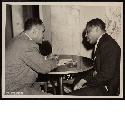 Ralph Bunche and unidentified man talking at table