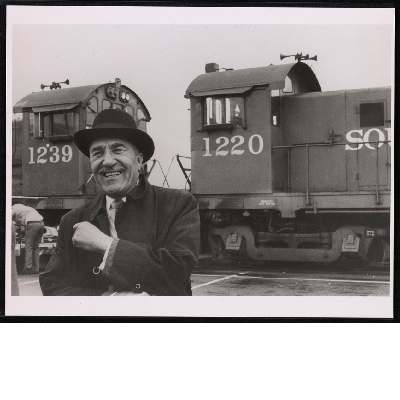 C.L. Dellums smiling standing in front of locomotive