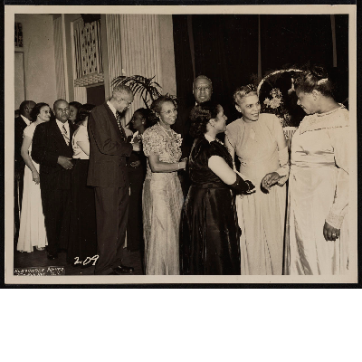 Group of men and women shaking hands at banquet