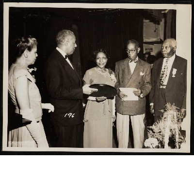 Presentation of plaque to Mrs. Agnes Thornton of Chicago Ladies Auxiliary to the Brotherhood of Sleeping Car Porters for bringing in largest number of new members, also pictured (left-right): Helena Wilson, A. Philip Randolph, Mrs. Thornton, Ernest Smith, John C. Mills