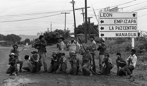 Sandinistas pose in front of a road sign, Nicaragua, 1979