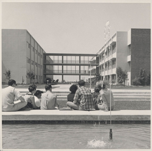 Photograph of students sitting by a fountain outside the Science Building