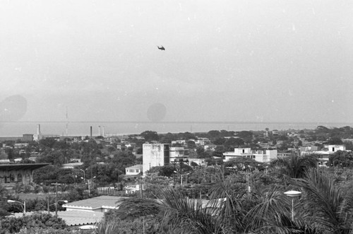 Helicopter hovers over a city, Nicaragua, 1979