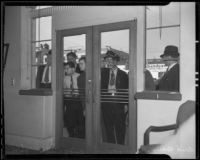 Spectators looking into Bank of America after robbery, Los Angeles, 1936