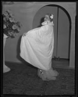 Woman models white fur evening cape at the Times' fashion show, Los Angeles, 1935