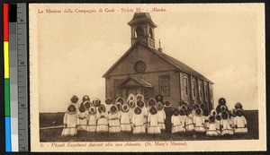 Children gathered in white clothing before a wooden Catholic church, Alaska, ca.1920-1940
