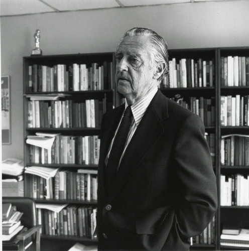 Dr. Tegner standing before the bookshelves in his office