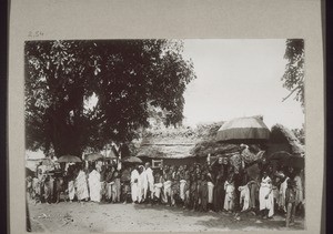 Chief being carried in procession through a town
