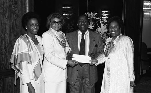 African American man with women receiving an award, Los Angeles, 1987