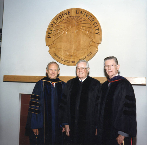 Dean Wilburn, Ross Blakely, and Chancellor Runnels beneath the Pepperdine University seal