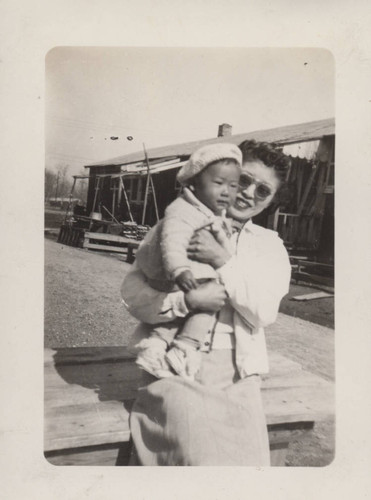 Woman holding baby wearing beret at Poston incarceration camp