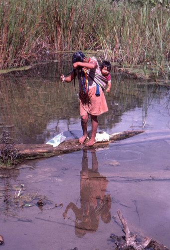 Guatemalan refugee washing her hair at a river, Cuauhtémoc, 1983