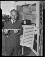 Floyd D. Young, meteorologist, standing outside beside a hydrograph, Pomona, 1935