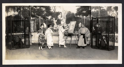 Artist paints at an easel while three onlookers watch /