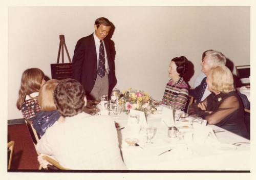 Dr. William Banowsky speaking, presenting a bronze Dedication Plaque; on the far side of the table Mrs. Alice Tyler is seated; next to her is Dr. Bob Bales--Pose 2 (Color)