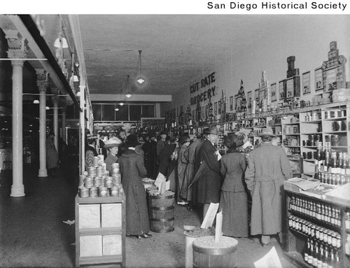 Group of men and women at the counter of the Cut Rate grocery store