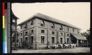 People gathering outside a large brick school building, Madagascar, ca.1920-1940