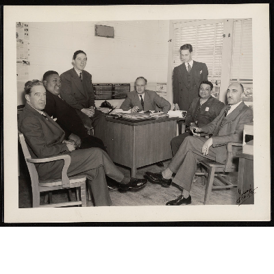 C.L. Dellums with six unidentified men in office