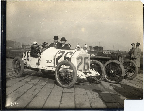 [Group of people posing with a racing car at the Panama-Pacific International Exposition]